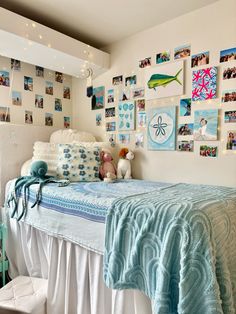 there is a bed with pictures on the wall and stuffed animals in front of it