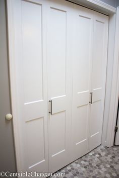 a white closet with two doors and a checkered floor in a room that has gray tile on the floor