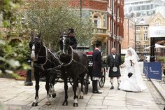 the bride and groom are riding in a horse drawn carriage down the street with their bridal couple