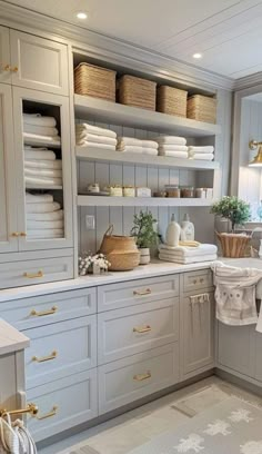 a white and gray kitchen with lots of shelves on the wall next to the sink