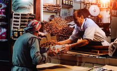 two people working in a store selling nuts