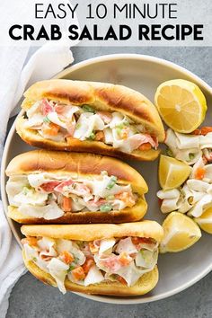 the crab salad sandwich is cut in half and served on a plate with lemon wedges