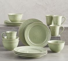 a set of green dishes and cups on a table