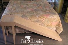 a bed that is made up and has a wooden frame on the headboard, along with a quilted bedspread