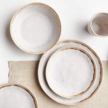 the table is set with white dishes and utensils