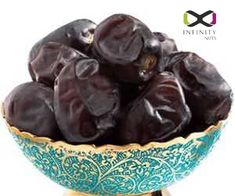 a bowl filled with black olives sitting on top of a table