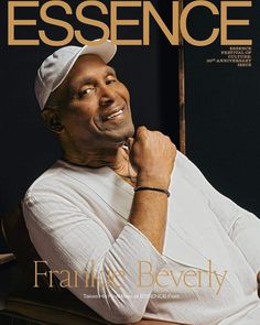 a man sitting on top of a wooden chair in front of a magazine cover with an image of him smiling