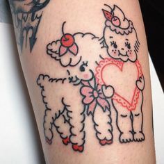 a tattoo on the leg of a woman with sheep and heart