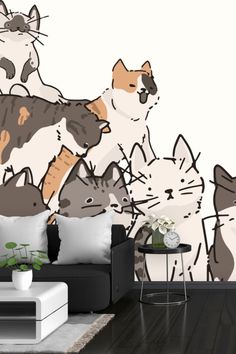 a living room filled with furniture and a cat wall mural on the wall behind it