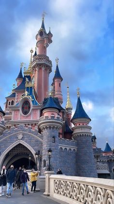 people are walking in front of a castle