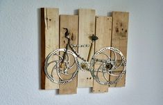 a bike made out of wooden pallets mounted to the wall with chains on it