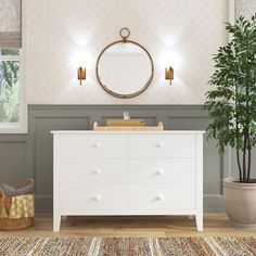 a white dresser sitting next to a potted plant