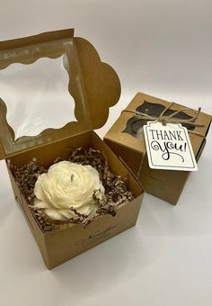 an open box with a cupcake in it and a thank you sign on the lid