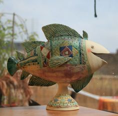 a ceramic fish sitting on top of a wooden table