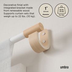 the curtain rod is attached to the wall with an extra long white handle and two round wooden hooks