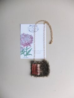 "These delicate and delightful all natural woven necklaces are inspired by botanical drawings of Dutch flowers found in a 1971 gardening book \"12 Months of Gardening\" passed down from my partner's grandfather. Every necklace is accompanied by the botanical illustration it is based on, as well as the fibers and materials used to make the piece. -Callistephus Each tiny weave is completely unique even if the same floral illustration is used. All fibers used are natural yarns such Mohair, Wool, Cotton, Linen, Silk or Bamboo. The chain is Gold filled - A great quality mixture of 14k gold and bronze, that never tarnishes. The chain is 46cm long. These unique floral woven-art necklaces come in beautiful narrow grey linen boxes with the FynBosch logo and the info label on the inside. Custom Requ Woven Necklace, Illustration Botanique, Fiber Jewelry, Art Necklaces, Botanical Drawings, Weaving Art, Floral Illustrations, Necklace Sizes, Gold Filled Chain