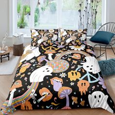 a bed covered in black and white sheets with colorful cartoon characters on the comforter