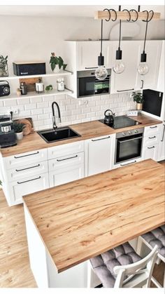 a kitchen with white cabinets and wooden counter tops