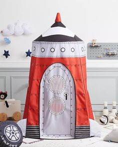 an inflatable rocket ship toy sitting on top of a white floor next to other toys