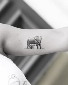 an elephant tattoo on the arm of a woman's left arm, which is black and white