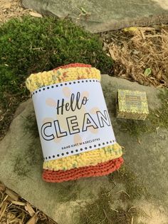 a roll of yarn sitting on top of a rock next to a patch of grass