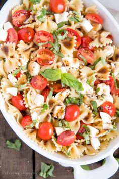 a pasta salad with tomatoes, mozzarella and basil