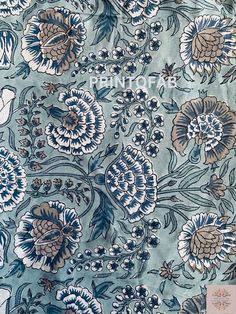 a blue and white floral print fabric with large flowers on the bottom half of it