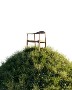 a chair sitting on top of a grass covered hill