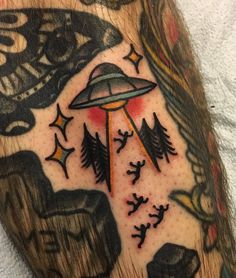 a close up of a person's arm with an alien tattoo design on it