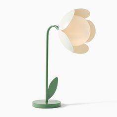 a green lamp with a white flower on it's base and a light bulb in the middle