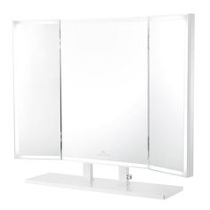 a white bathroom mirror sitting on top of a counter next to a shelf with two mirrors