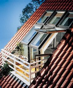 an orange tiled roof with several windows on each side and a skylight above it