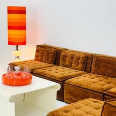 a living room filled with furniture and a lamp on top of a white coffee table