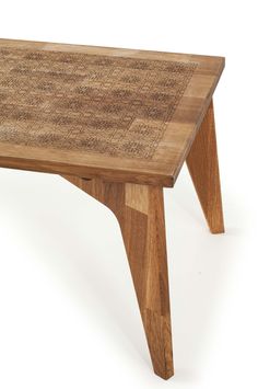 a wooden table with an intricate design on the top and bottom, sitting against a white background