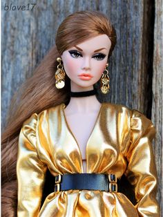 a close up of a barbie doll wearing a gold dress