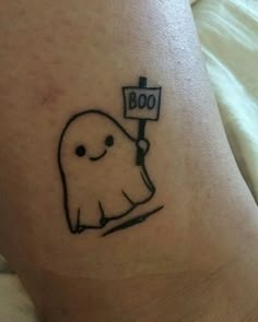 a tattoo with a ghost holding a sign that says boo