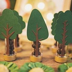 small trees are placed on top of each other in front of some cookies and candies