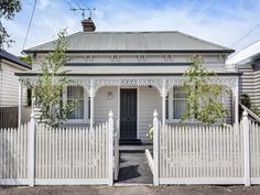 a white house with a picket fence in front of it