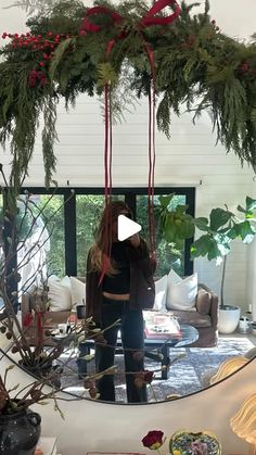 a woman standing in front of a mirror with christmas decorations hanging from it's sides