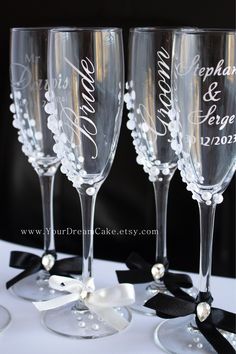 three wine glasses with names on them sitting next to each other and black ribbon around the edges