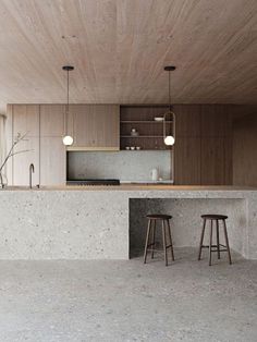 an empty kitchen with two stools in it