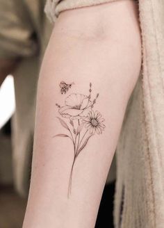 a woman's arm with flowers and a butterfly tattoo on the left inner arm