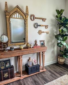 there is a mirror and some keys on the wall next to a table with suitcases