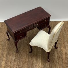 an antique desk and chair are on the floor