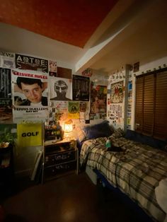 a bedroom with posters on the wall and a bed in front of a lamp that is turned on