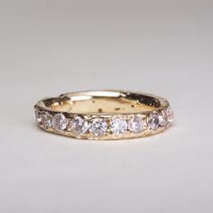 a gold wedding band with five diamonds on the inside and outside, set in 18k yellow gold