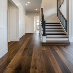 an empty hallway with wooden floors and white walls