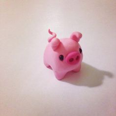 a pink toy pig sitting on top of a table