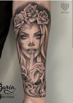 a woman's arm with roses and a skull on it