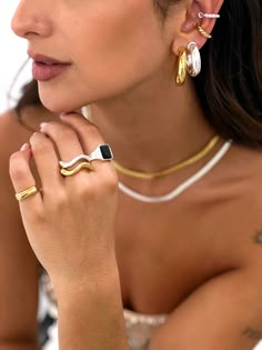 a woman wearing two different rings on her left hand and one with an earring